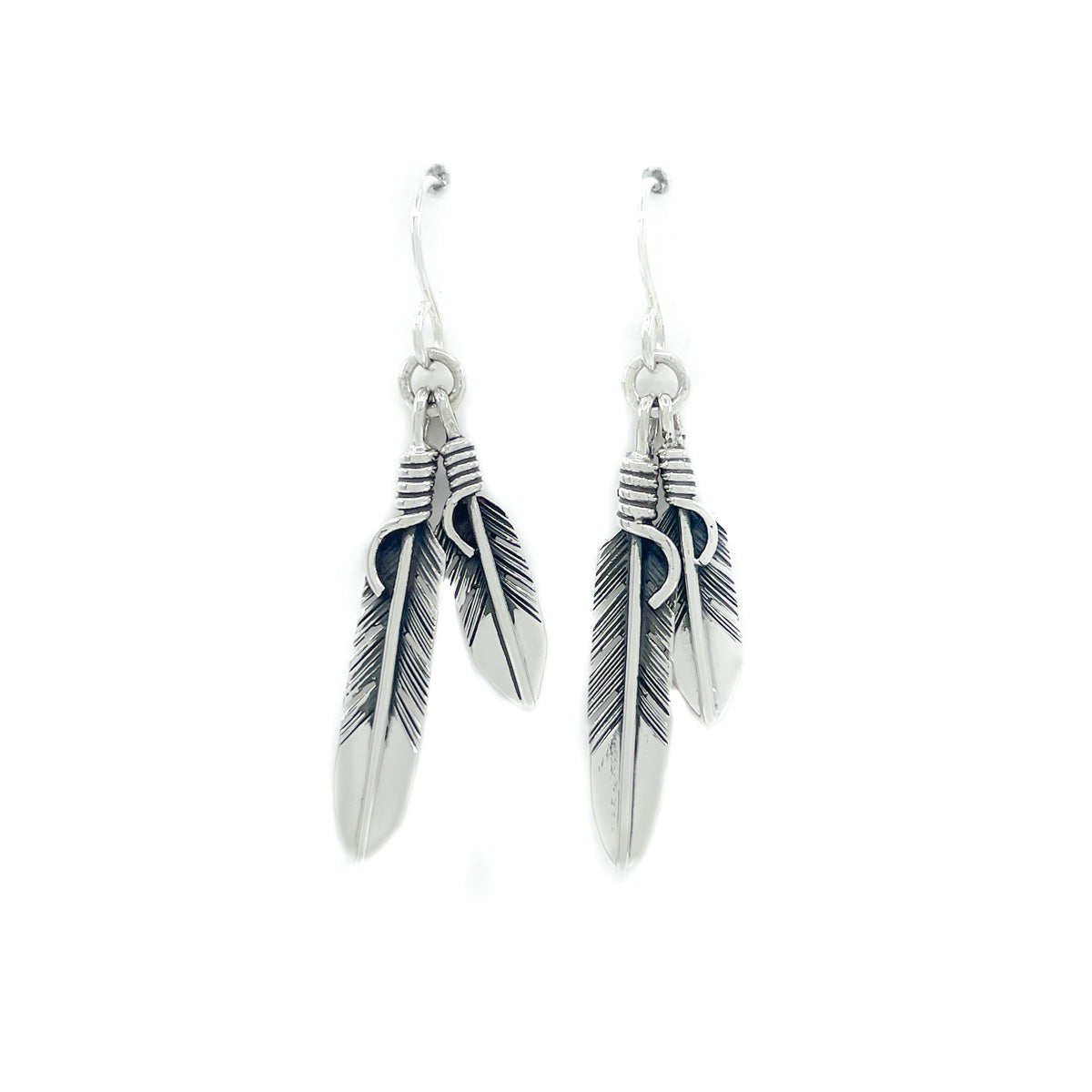 Sterling silver double feather earrings with sterling silver wires Small feather measures approx. .75 inches, large feather measures approx. 1.25 inches, dangles from ear lobe approx. 2 inches  When worn, the movement of the two dangling feathers gives nice, sparkly effect