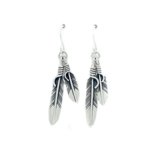 Sterling silver double feather earrings with sterling silver wires Small feather measures approx. .75 inches, large feather measures approx. 1.25 inches, dangles from ear lobe approx. 2 inches  When worn, the movement of the two dangling feathers gives nice, sparkly effect