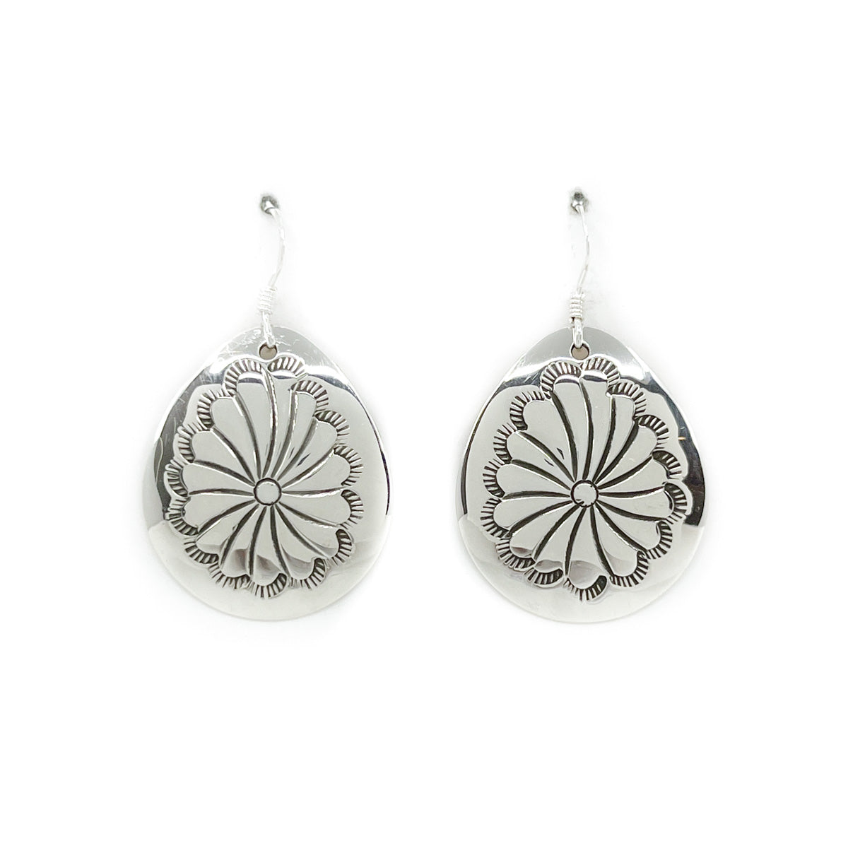 Hand stamped sterling silver drop earring with sterling silver wires By Diné silversmith, Janet Manuelito Stampwork may vary slightly with each pair Measures approximately 1 inch long by 1 inch wide, dangles 1.5 inches from earlobe *All sales on jewelry are final. No returns or exchanges.